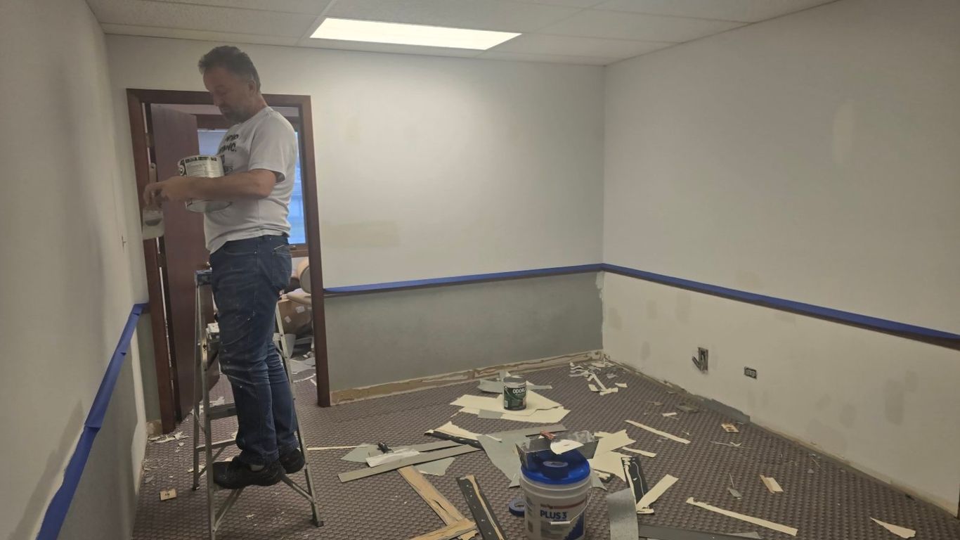 A person is painting a room that is undergoing renovation.
