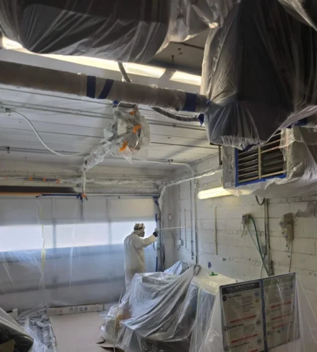 professional spray painter refinishing a modern almirah with smooth flawless finish