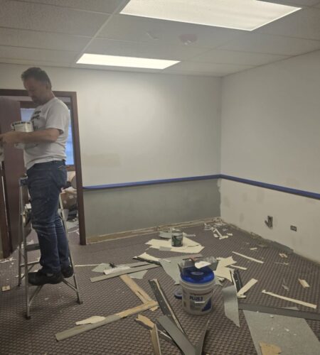 A professional painter working on a home kitchen renovation project.
