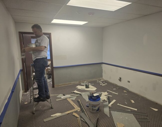 A professional painter working on a home kitchen renovation project.