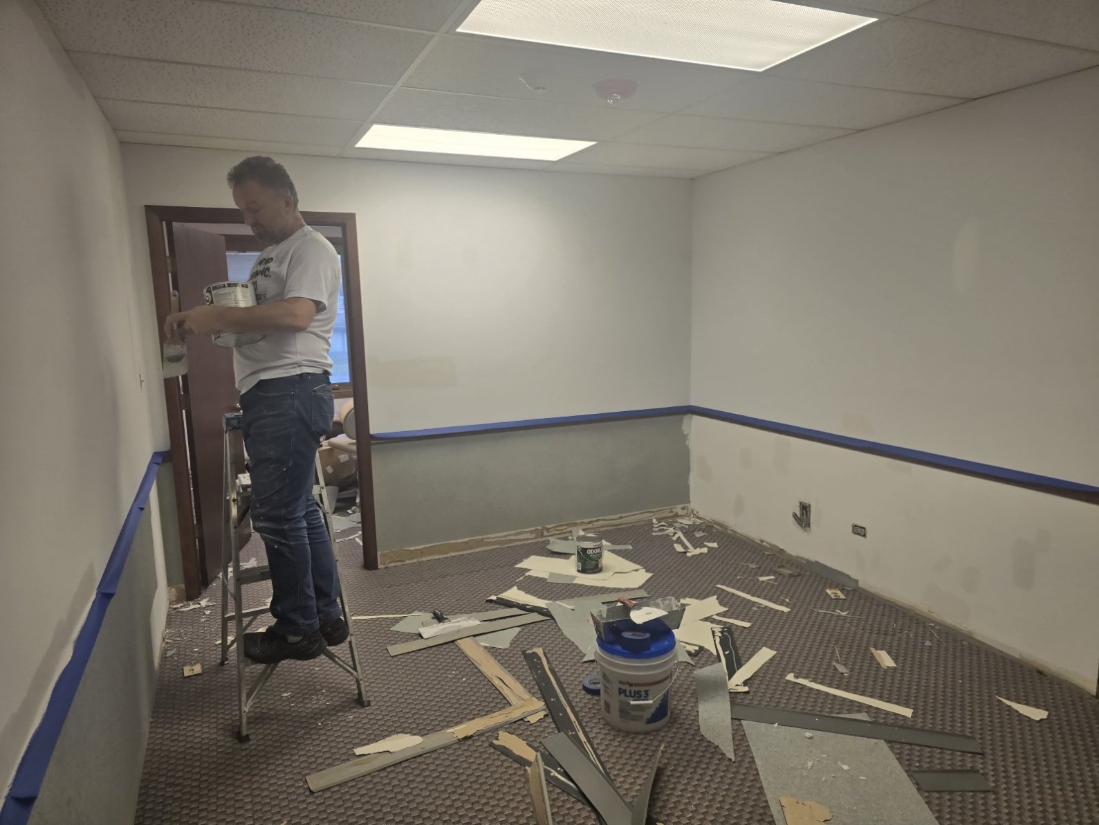 A professional painter working on a home kitchen renovation project.