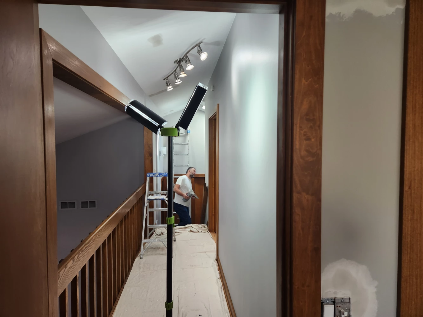 Professional painter working on a high ceiling project with safety equipment.