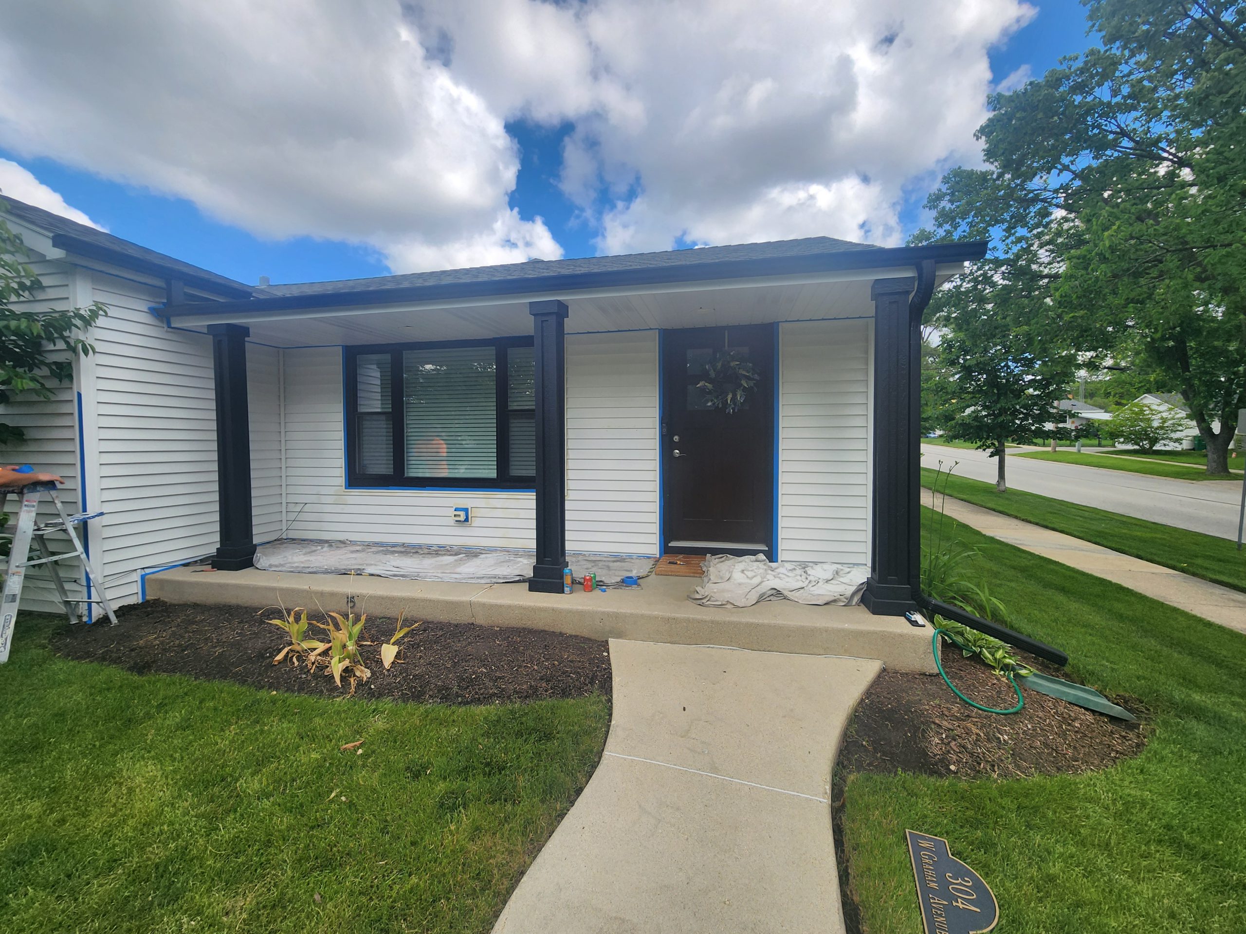 Lombard home exterior being painted with crisp white siding and black trim