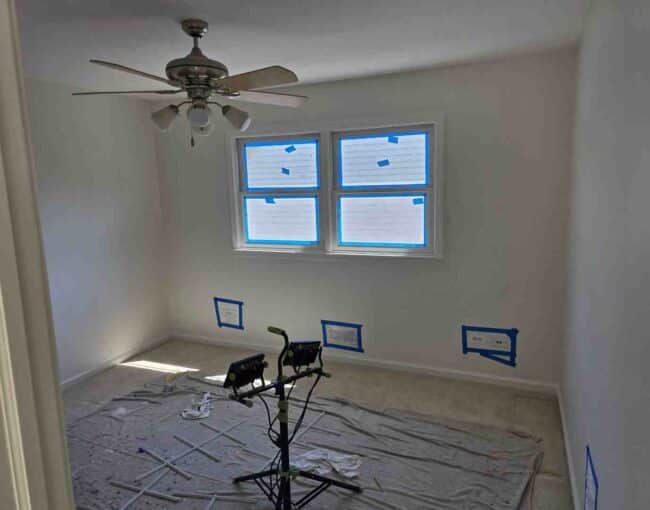 Small modern living space with seamless flat white ceiling and bright ambient lighting