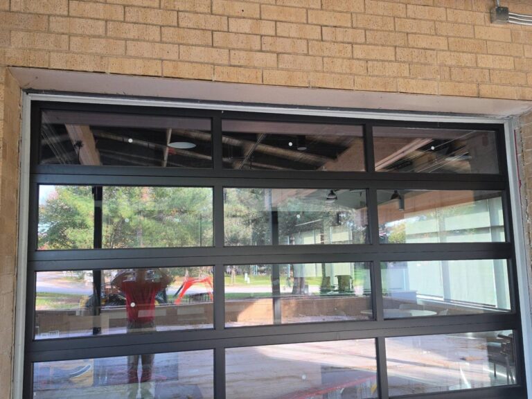 Metal header above a glass overhead door before painting at a commercial building in Elmwood Park, IL