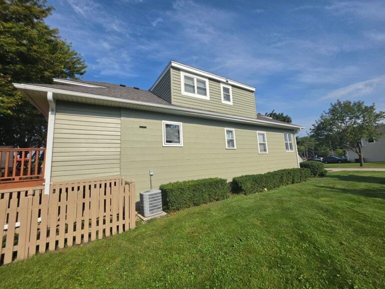 Painted sage green lap siding with white trim on a house with a dormer in Hanover Park, IL