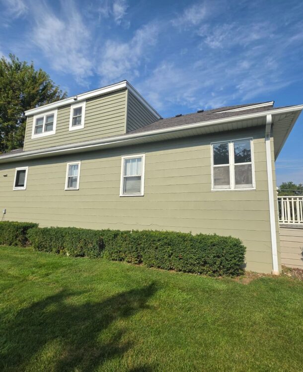 Side of a house with freshly painted sage green siding and white window trim in Hanover Park, IL