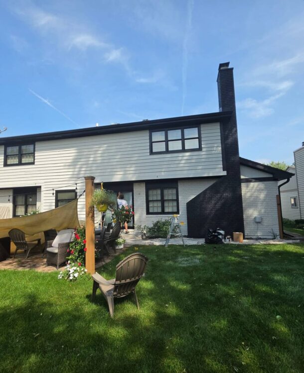 Back of a house in Wheaton, IL painted white with black trim and a brick chimney painted black