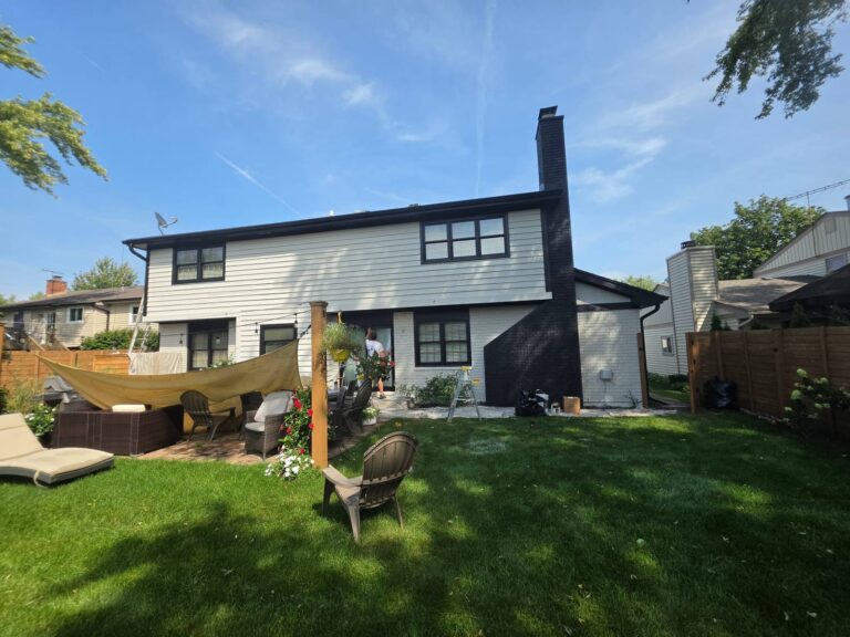 Back of a house in Wheaton, IL painted white with black trim and a brick chimney painted black