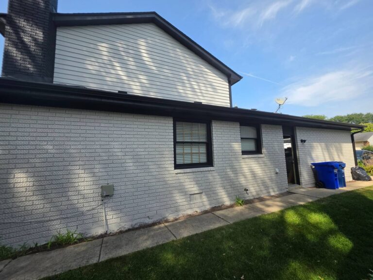 Brick wall painted white with black window trim and fascia on a house in Wheaton, IL